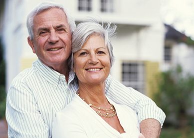 Older couple in front of home